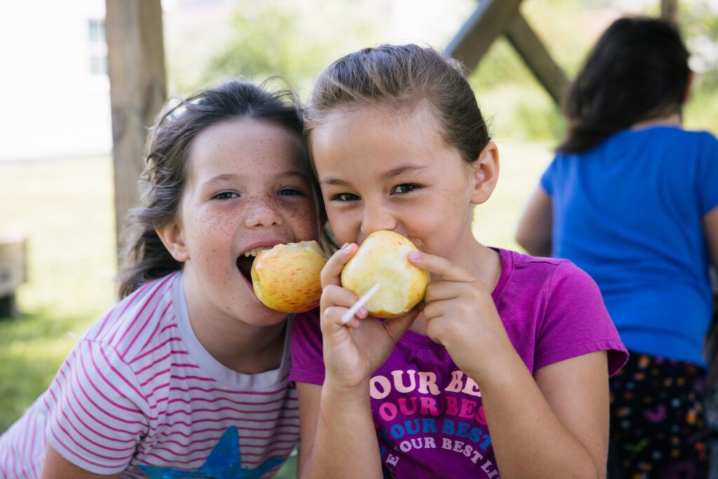 Kids enjoying eating apples outside