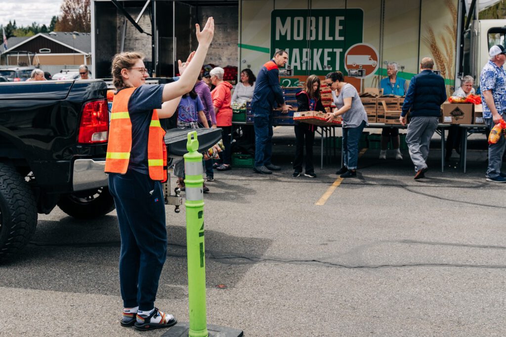 Volunteer directing traffic at a Mobile Market event