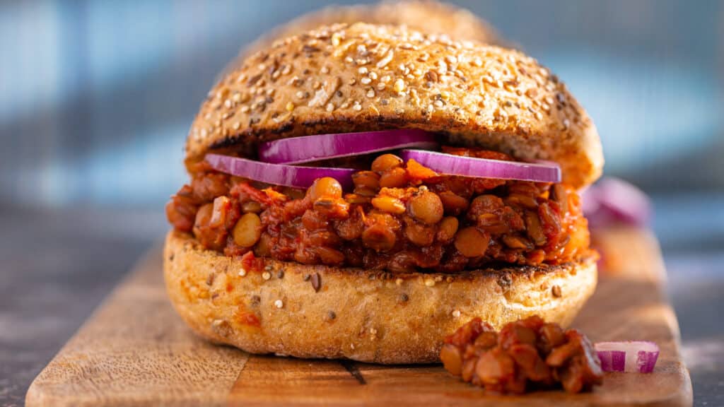 Vegan Sloppy Joe Burger Lentils and Red Onions on a Wooden Board